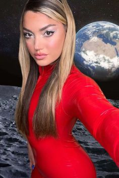 a woman in a red bodysuit pointing at the earth