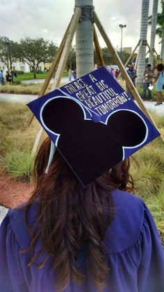 a person wearing a graduation cap with a mickey mouse design on it's back