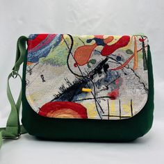 Green flap bag Height 26 cm 10.23 inch Top length 29 cm 11.41 inch Bottom length 32 cm 12.60 inch Shoulder strap 116 cm 45.67 inch Its capacity is quite generous and can accommodate a small 0.5 liter bottle upright. It is lined with khaki cotton fabric and has a patch pocket inside. The bag is fully canvassed to reinforce the seams and fabrics and ensure good fit. The handle is a green strap and it is adjustable. On the flap, an elongated wooden bead indicates the magnetic clasp. UNIQUE PIECE Se Magnetic Clasp, Flap Bag, Wooden Beads, Cross Body Handbags, Inside Pocket, Purses And Handbags, Patch Pocket, Unique Pieces, Shoulder Strap