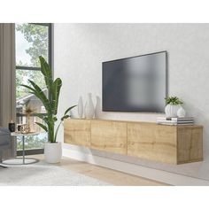 a large flat screen tv mounted to the side of a wooden cabinet in a living room