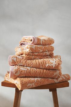 a stack of towels sitting on top of a wooden stool