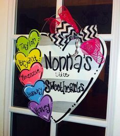 a heart shaped sign hanging from the side of a window with words written on it