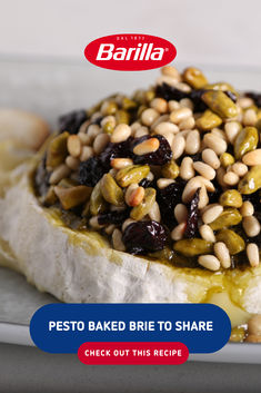 a white plate topped with bread covered in nuts and olives on top of it