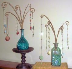 three vases are sitting on a table with beads and necklaces hanging from them