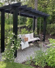 a white couch sitting on top of a wooden bench next to a lush green forest