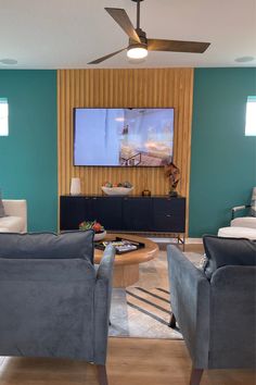 a living room with two couches and a flat screen tv mounted on the wall