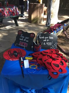 a blue table topped with lots of red and black items on top of a blue cloth