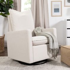 a living room with a chair, rug and pictures on the wall behind it in front of a window