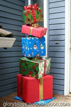 three presents stacked on top of each other with christmas wrapping around them and wrapped in ribbon