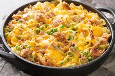 a casserole dish with chicken, peas and cheese in a cast iron skillet