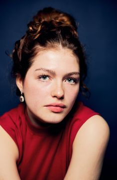 a young woman in a red shirt posing for a photo