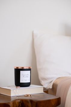 a candle sitting on top of a book next to a bed