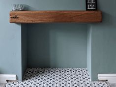 a wooden shelf above a tiled floor in a room with blue walls and white trim