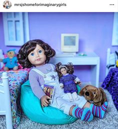 a doll sitting on top of a blue bean bag chair next to a stuffed animal