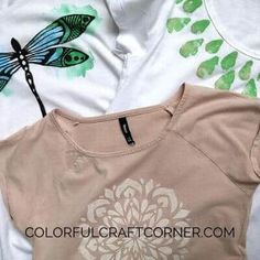 two t - shirts with dragonflys on them are laying next to each other