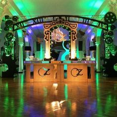 the dance floor is lit up with green and purple lights