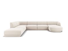 a white sectional couch sitting on top of a white floor next to a chair and ottoman