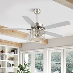 a ceiling fan in a living room with windows