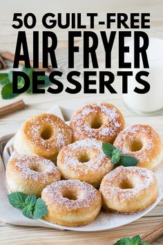 a plate filled with powdered sugar covered donuts on top of a wooden table