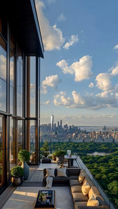 an outdoor living area with couches, tables and windows overlooking the cityscape