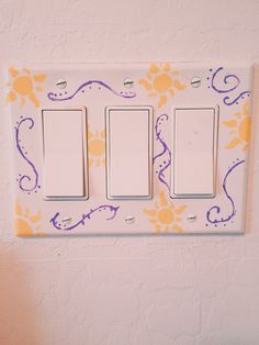 a white light switch sitting on top of a wall next to a yellow and purple flower pattern