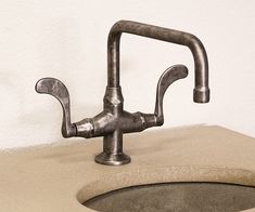 a faucet that is sitting on top of a sink in a room with white walls