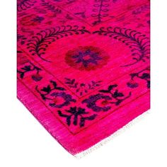 a pink rug with black and purple designs on it's edges, against a white background