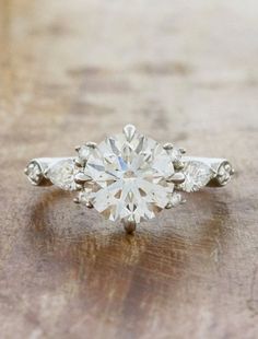 a diamond ring sitting on top of a wooden table