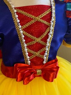 a close up of a dress on a mannequin wearing a red, yellow and blue costume