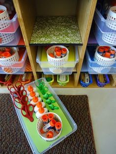 scissors and other crafting supplies are on the floor in front of storage bins