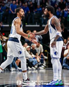 two basketball players shaking hands on the court