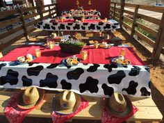 a table set up with hats and food on it for a cow themed birthday party