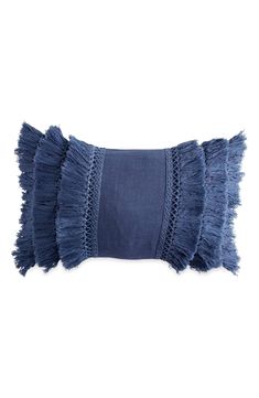 a blue pillow with fringes on the front and back of it, against a white background