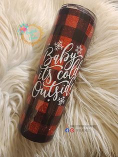 a red and black plaid tumbler with the words baby it's cold outside