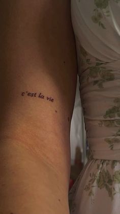 the back of a woman's arm with an inscription on it that reads, est est la vie