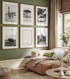 a living room with green walls and pictures on the wall above the couch, along with vases filled with flowers