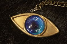 a gold necklace with an evil eye and zodiac sign on it's center piece