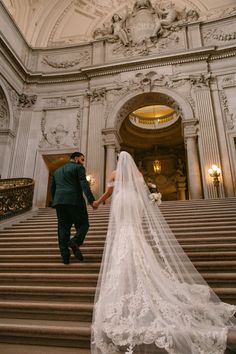 the bride and groom are walking down the stairs at their wedding ceremony in san francisco city hall