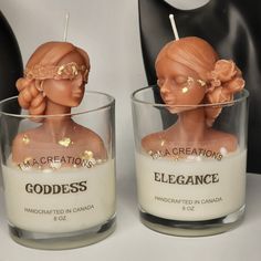 two candles that have been made to look like the head of a doll in a glass