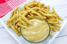 a white plate topped with french fries and dip