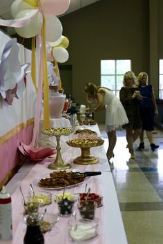 a buffet table with desserts and balloons on it