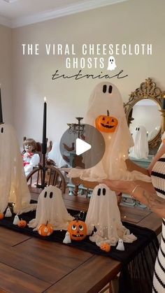 a woman standing in front of a table with ghost decorations on it and candles lit up