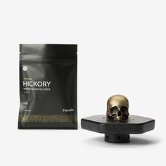 a gold skull sitting on top of a black stand next to a bag of coffee