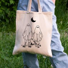 a person holding a bag with two ghost on it