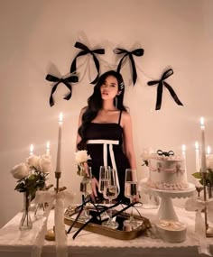 a woman standing in front of a table filled with cake and wine glasses