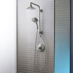 a shower head with thermostaer and hand held shower faucet in front of it