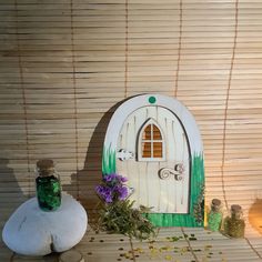 a wooden fairy door surrounded by bottles and flowers