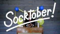 a person sitting at a desk with balloons and confetti on it that says socktober