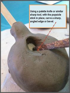 a clay pot with a stick sticking out of it