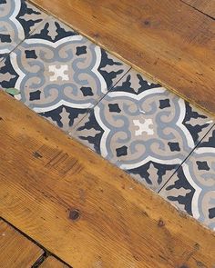 the floor is covered with an intricately designed tile and wood planks that are being used as a bench